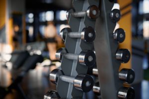 Rack with dumbbells of different weights at sport gym center