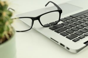 Laptop, glasses and plant, close up, business concept