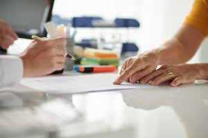 Senior Woman Signing Document